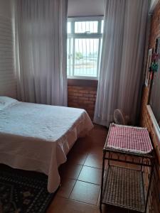 1 dormitorio con cama y ventana en Casa do Mar en Guarapari