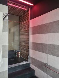 a bathroom with a walk in shower and a glass wall at Home 101 in Calasetta