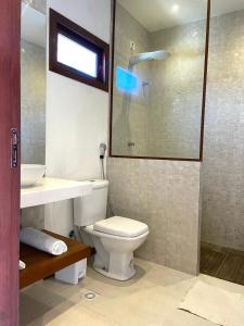 a bathroom with a toilet and a sink and a shower at Vila Mandakaru in São Miguel do Gostoso