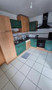 a kitchen with green cabinets and a white tile floor at Chambre centre ville de Cluses in Cluses