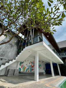 a building with a staircase and a mural on the wall at Supreme Siam Resort in Koh Samui 