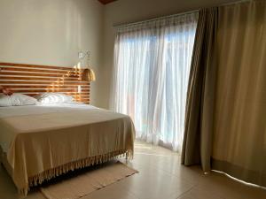 a bedroom with a bed and a large window at Vila Mandakaru in São Miguel do Gostoso