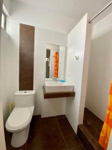 a bathroom with a toilet and a sink at Condominio Nuevo Paracas - Sotavento in Paracas