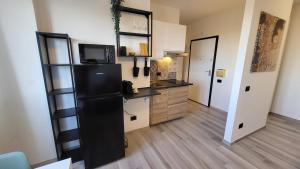 a kitchen with a black refrigerator in a room at Alloggio sul parco in Modena