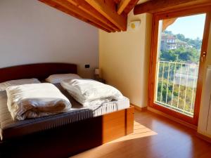 1 dormitorio con 2 camas y ventana grande en Soffio Di Rugiada - spacious terrace with Lake view, en Fonteno