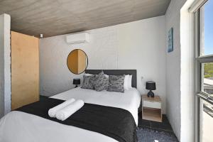een slaapkamer met een groot wit bed en een spiegel bij Modern Living Mountain&ocean View 100m To Beach in Kaapstad