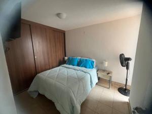 Paraíso escondido في كوبان: غرفة نوم عليها سرير ومخدات زرقاء