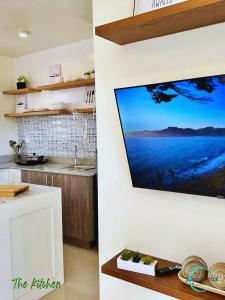 eine Küche mit einem an der Wand hängenden TV in der Unterkunft Lovely Homes at Casa Mira Bacolod in Bacolod City