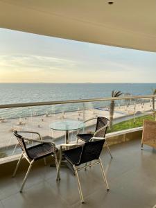 a balcony with a table and chairs and the ocean at Condominio Nuevo Paracas - Sotavento in Paracas