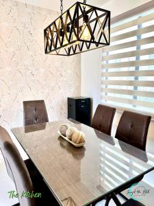 ein Esszimmer mit einem Tisch und Ledersesseln in der Unterkunft Lovely Homes at Casa Mira Bacolod in Bacolod City