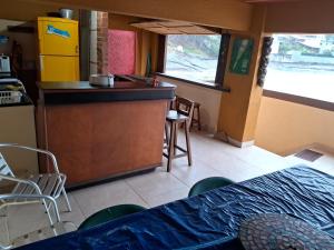 a kitchen with a counter and a kitchen with chairs at Casa do Mar in Guarapari
