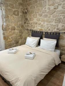 a large white bed with two towels on it at Maison le Bac Paris Aparthotel in Paris