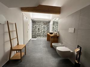 uma casa de banho com um WC, um lavatório e uma cadeira em Nido di Laura em Santa Maria Maggiore