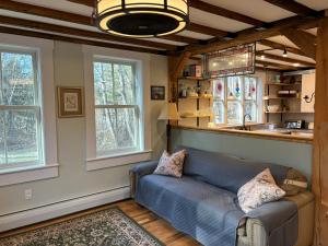a living room with a couch and two windows at Cozy 1882 renovated cape in Plainfield
