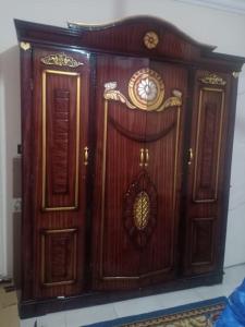 een houten kast met twee deuren in een kamer bij Lovely 1-bedroom rental unit in Cornish El Maadi - Males only in Caïro