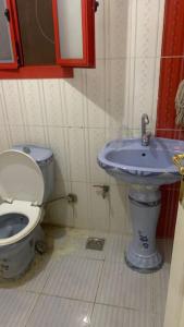 een badkamer met een toilet en een blauwe wastafel bij Lovely 1-bedroom rental unit in Cornish El Maadi - Males only in Caïro
