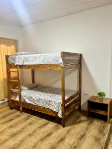 two bunk beds in a room with a wooden floor at ROOM AYAMPE - La Casa de Eros in Ayampe