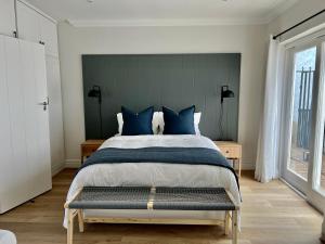 a bedroom with a large bed with blue pillows at Villa Moselle - St James in St. James