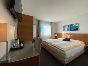 ルツェルンにあるビジネスホテル ラックスのベッドとデスクが備わるホテルルームです。