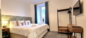 a bedroom with a bed with a television and a mirror at CHARMING VICTORIAN APARTMENT, central location in Inverness