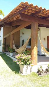 d'une terrasse avec deux hamacs sous une pergola. dans l'établissement Casa de ferias paraíso, à Santa Cruz Cabrália