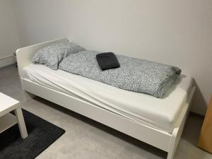 Una cama blanca con una almohada negra. en Zentrum Kassel 2 en Kassel