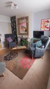 a living room with a couch and a table at Comfortable artistic house welcomes you! in Oxford