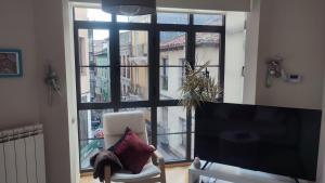 a living room with a large window and a television at Estudio Paloma in León