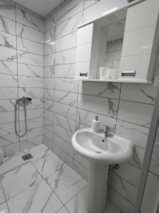 a white bathroom with a sink and a mirror at Royal Stars Apartments in Strumica