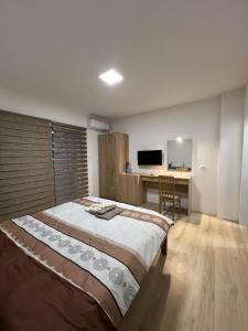 sypialnia z dużym łóżkiem i biurkiem w obiekcie Royal Stars Apartments w mieście Strumica