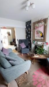 sala de estar con sofá azul y espejo en Comfortable artistic house welcomes you! en Oxford