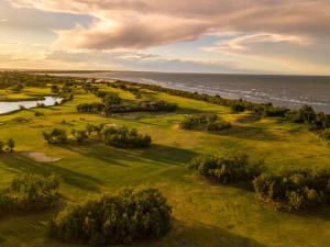 una vista aérea de un campo de golf cerca del océano en Hotel Formula Int. & Puravita SPA, en Rosolina