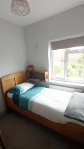 a bedroom with a bed and a window at Comfortable artistic house welcomes you! in Oxford