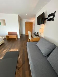 ein Wohnzimmer mit einem Sofa und einem Schreibtisch in der Unterkunft Businesshotel Lux in Luzern