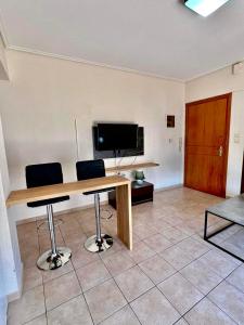a room with a table and two chairs and a television at Central appartment 2 with parking in Larisa