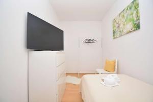 a white room with a tv and a bed at KU01-RI Apartment in Kulmbach EG in Kulmbach