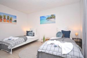 two beds in a white room with acknowled at KU01-RI Apartment in Kulmbach EG in Kulmbach