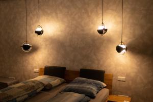 two beds in a room with lights on the wall at Ruhiges & luxuriöses Business Apartment im Zentrum in Chemnitz