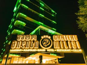 a building with a neon sign in front of it at Chateau Milisi in Batumi