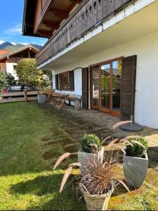 ein Haus mit zwei Topfpflanzen in einem Hof in der Unterkunft Ferienwohnung Bergrausch in Kreuth