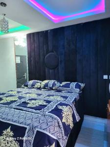 Schlafzimmer mit einem Bett mit einer schwarzen und weißen Bettdecke in der Unterkunft O'ffidaus J Luxury Hotel And Suites Int Ltd in Benin City
