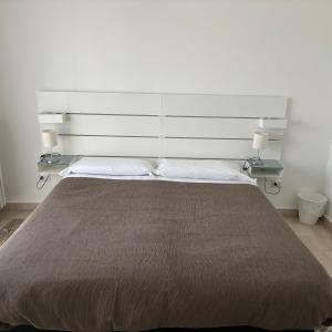 a bedroom with a large bed with two lamps at ESSENTIAL ROOM & PARKING in Centro Città con Parcheggio Privato e WIFI in Potenza +28 photos