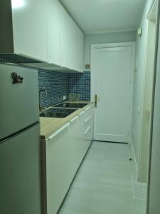 a kitchen with white cabinets and a white tile floor at Apartment Casa M in Morro Jable in Morro del Jable