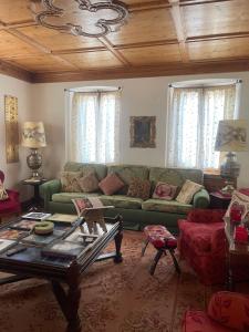 a living room with a green couch and a table at Bike and Ski dreams in Cortina dʼAmpezzo