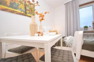 a dining room with a white table and a couch at KU-02RI Apartment in Kulmbach OG in Kulmbach