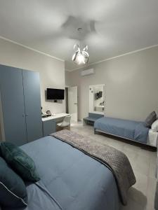 1 dormitorio con 2 camas y escritorio en B&B Girasoli, en Scafati