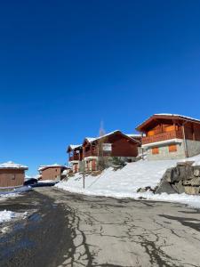 eine leere Straße vor Häusern im Schnee in der Unterkunft Chaleureux appartement grand panorama 2 avec piscine au pied des pistes in Valmeinier