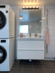 ein Badezimmer mit einem Waschbecken und einer Waschmaschine in der Unterkunft Bo bekvämt i eget hus in Ekeby