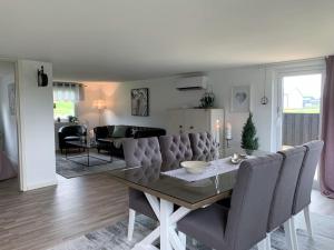 a dining room table with chairs and a living room at Bo bekvämt i eget hus in Ekeby