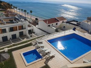 an overhead view of a swimming pool and the ocean at Magnifique Duplex avec piscine en bord de mer in Olhos de Água